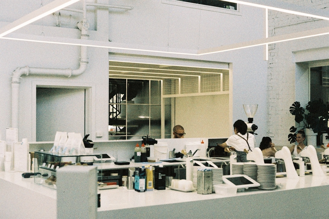 Ett modernt laboratorium med flera forskare i vita rockar som arbetar vid avancerade arbetsstationer.